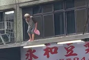 超狂嬤「腳踩屋簷」買早餐！跨越自家窗戶　下秒站招牌上…驚悚過程全曝光