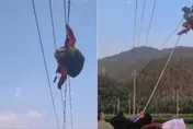影/飛到一半GG了…玩滑翔傘降掛在電纜線上　他驚喊「幫幫忙」靠村民搭梯脫困