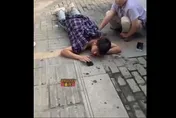 喊痛也沒用！重慶男子街頭遭捅　趴地淡定刷手機等救援