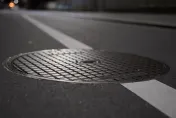 中和人孔蓋疑因短路突炸飛　路過騎士受驚自摔