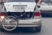 影/有夠扯！讓「孩子躲後車廂」徒手固定腳踏車　誇張爹要挨罰了