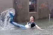 高雄遭凱米風雨侵襲慘變「水樂園」　壯漢苦中作樂變身「大美人魚」猛「甩尾」