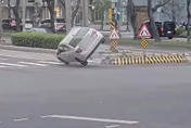 影/北市東區轎車自撞庇護島翻車　車頭撞爛駕駛狼狽爬出