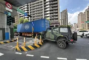 新北淡水貨櫃車轉彎「內輪差」釀禍！軍用吉普遭拖上安全島