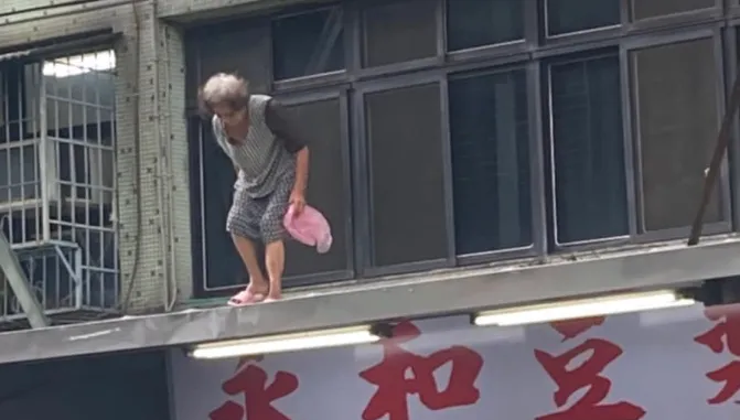 超狂嬤「腳踩屋簷」買早餐！跨越自家窗戶　下秒站招牌上…驚悚過程全曝光