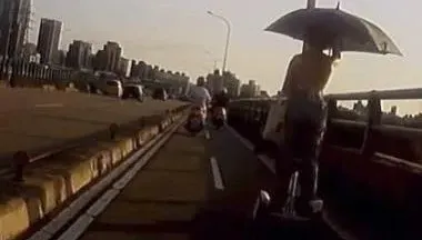 移動神主牌！露背辣妹撐大傘「踩平衡車」攻福和橋　騎士嚇歪