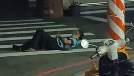 活膩了？詭異大叔深夜躺「斑馬線」上滑手機　網噴：車壓到算誰的