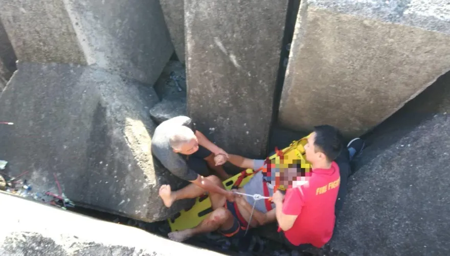 散步意外墜港！屏東男受傷卡消波塊　警消吊掛救援
