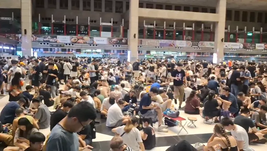 影/台鐵停駛北車卻被擠爆！颱風天萬人席地而坐　緊盯手機抓色違超夢