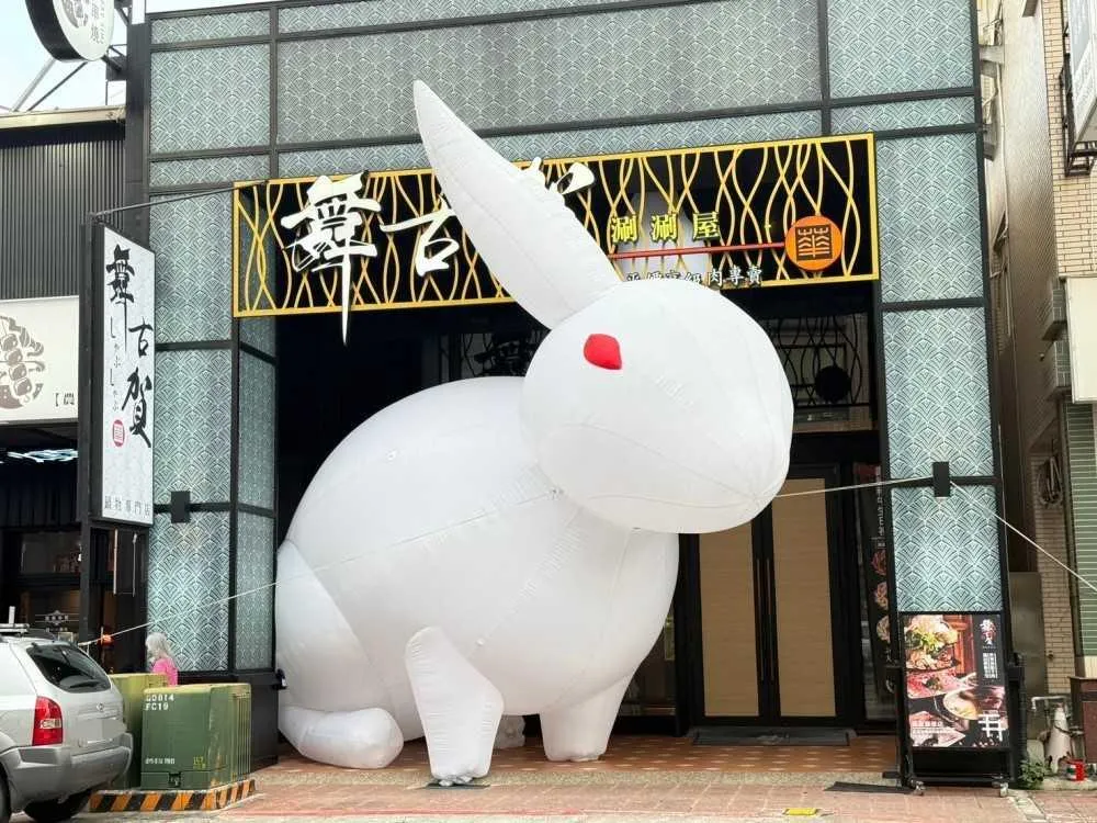 即日起至10月12日，民眾與高約8公尺的白色巨兔合照可獲贈鱈魚玫瑰花；若拍攝互動短影音，更可享有價值600元的炙燒火烤現切澳洲牛舌或台灣松阪豬（每桌限兌換乙份）。（圖／舞古賀mini鍋物提供）