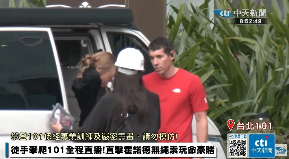 霍諾身穿招牌紅色T恤出現在台北101大樓。（圖／中天新聞，下同）