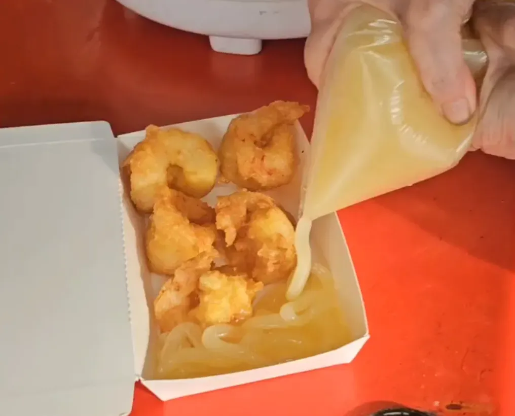 當事店家現場製作店內販售的炸蝦球，提到現在物價貴，餐點用到的沙拉醬也不便宜。（圖／中天新聞）