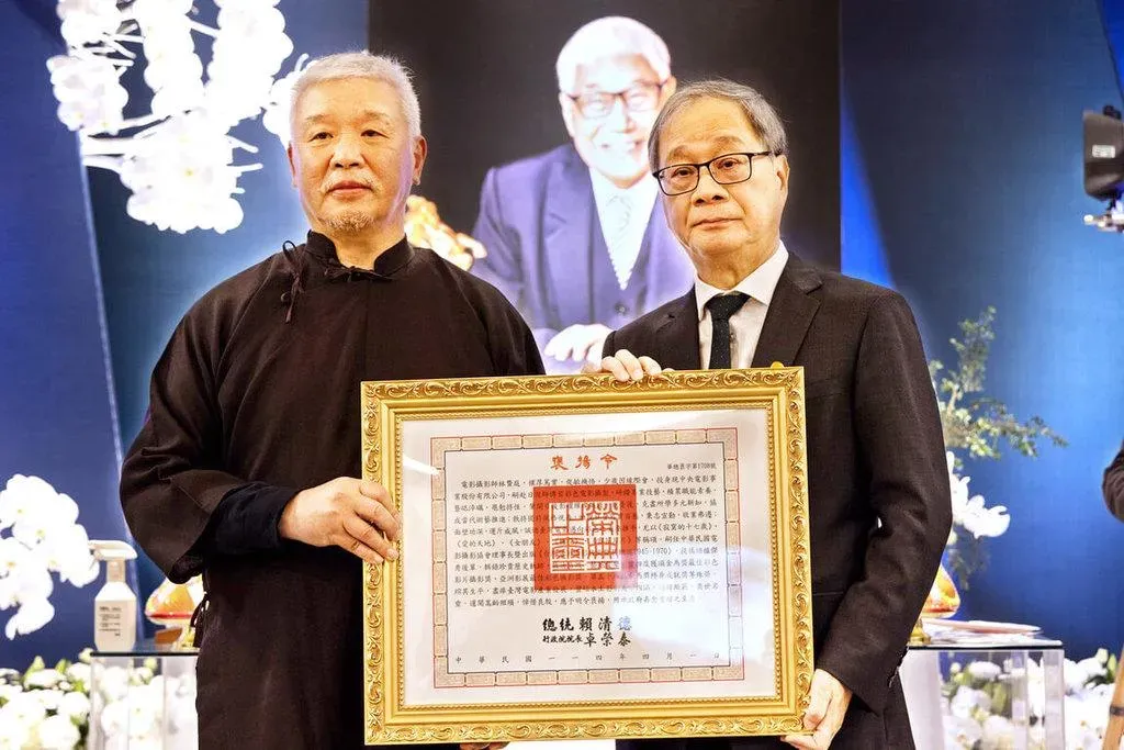 文化部長李遠(右)2日出席電影攝影師林贊庭告別式,並代表頒贈總統褒揚令,由林贊庭長子林良忠(左)代表受贈。(圖/文化部 提供)