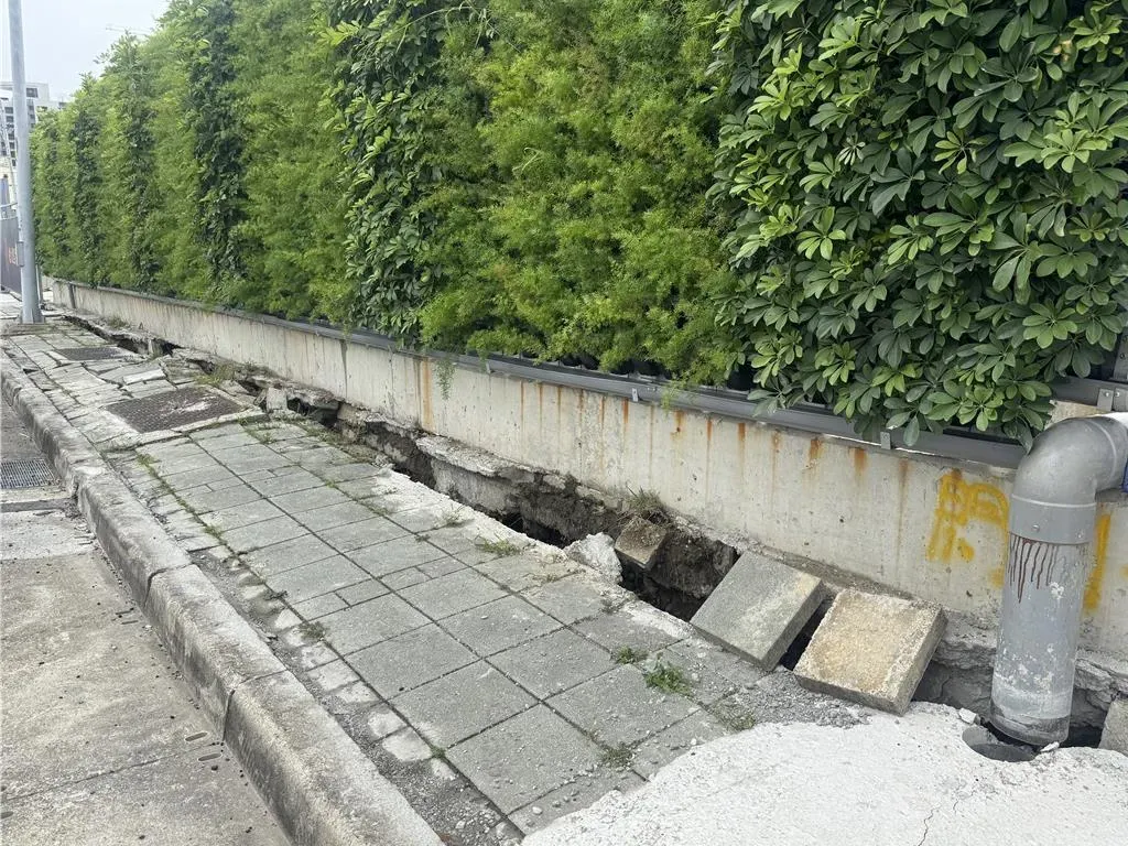 人行步道與建案圍籬有縫隙。（圖／中國時報潘虹恩攝）