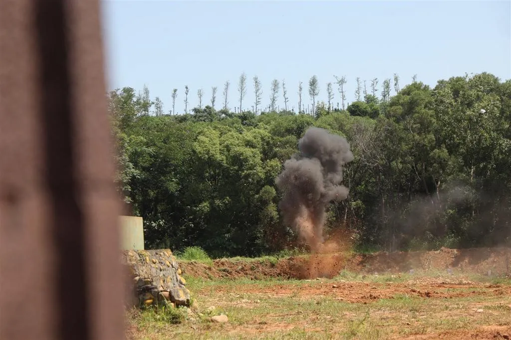 官兵按下引爆鈕，只見爆坑瞬間炸起數公尺高土石，同時伴隨轟隆巨響震撼訓場。(圖/青年日報)