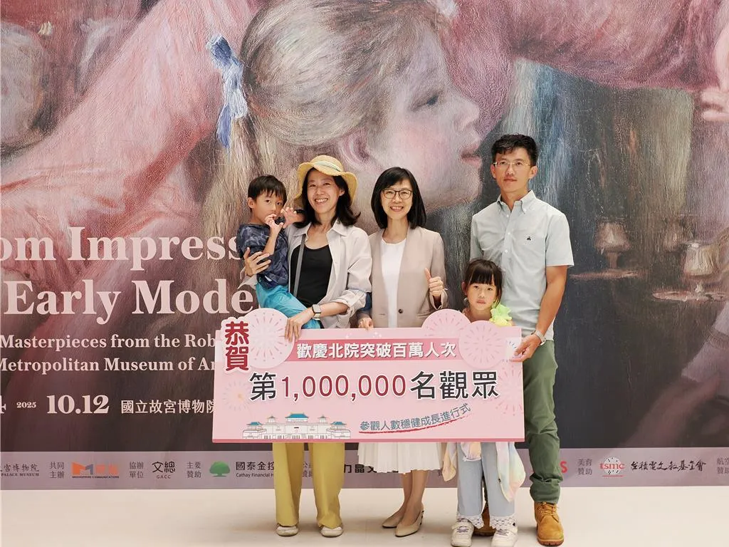 故宮余佩瑾副院長（中）代表歡迎並致贈禮物給第100萬人次的遊客，他們是來自高雄的楊先生一家人。（故宮提供）