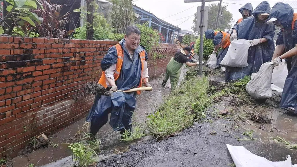 何博文2日率領中央黨部及地方黨部50多名志工，前往台南市後壁區菁寮國小，冒雨清理水溝。（圖/資料照）