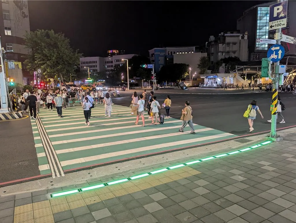 新北市交通局在板橋府中捷運站試辦「行人地面警示燈」，以同步發光的LED地磚提醒行人和駕駛當前號誌燈態。（圖／新北市交通局提供）