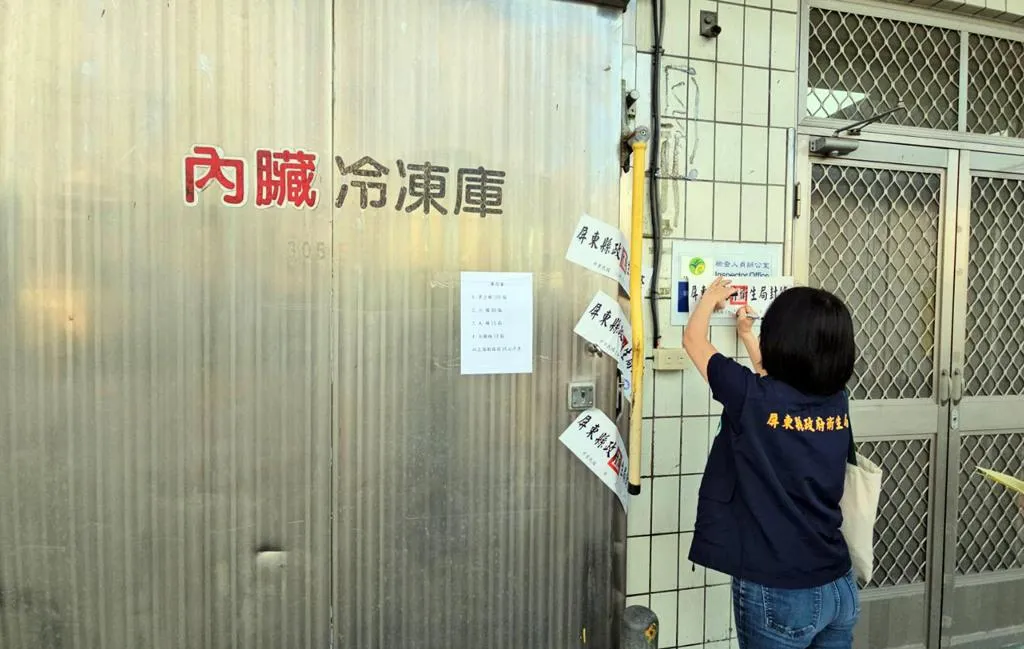 屏東縣衛生局人員在涉嫌加工黑心豬大腸的業者工廠貼封條。（圖／中時／林和生攝）