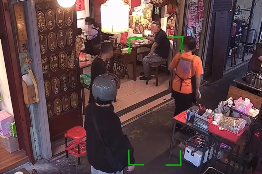 身穿黑衣、平頭，站立的男子，在台中市北區一間黑輪小吃店消費時，包包竟然掉出一把衝鋒槍，嚇壞所有人。（圖／翻攝照片）