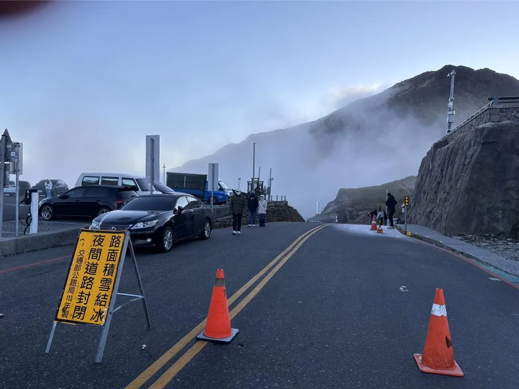 台14甲線合歡山水晶宮路段因低溫出現路面結冰，警方在現場設三角錐圍告示。（圖／警方提供）