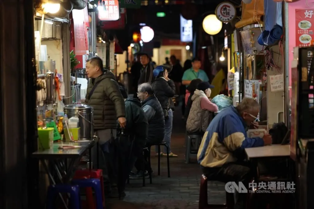 新北市汐止區民眾穿著保暖衣物在外品嚐美食。（圖／中央社）