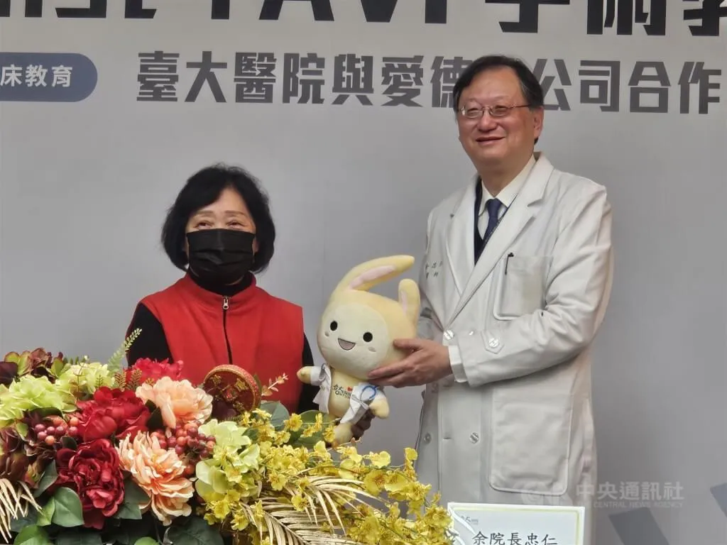 台大醫院心血管中心導入極簡式經導管主動脈瓣膜置換術，病患最快隔天可出院，院長余忠仁（右）致贈吉祥物醫寶玩偶給病友。（圖／中央社）