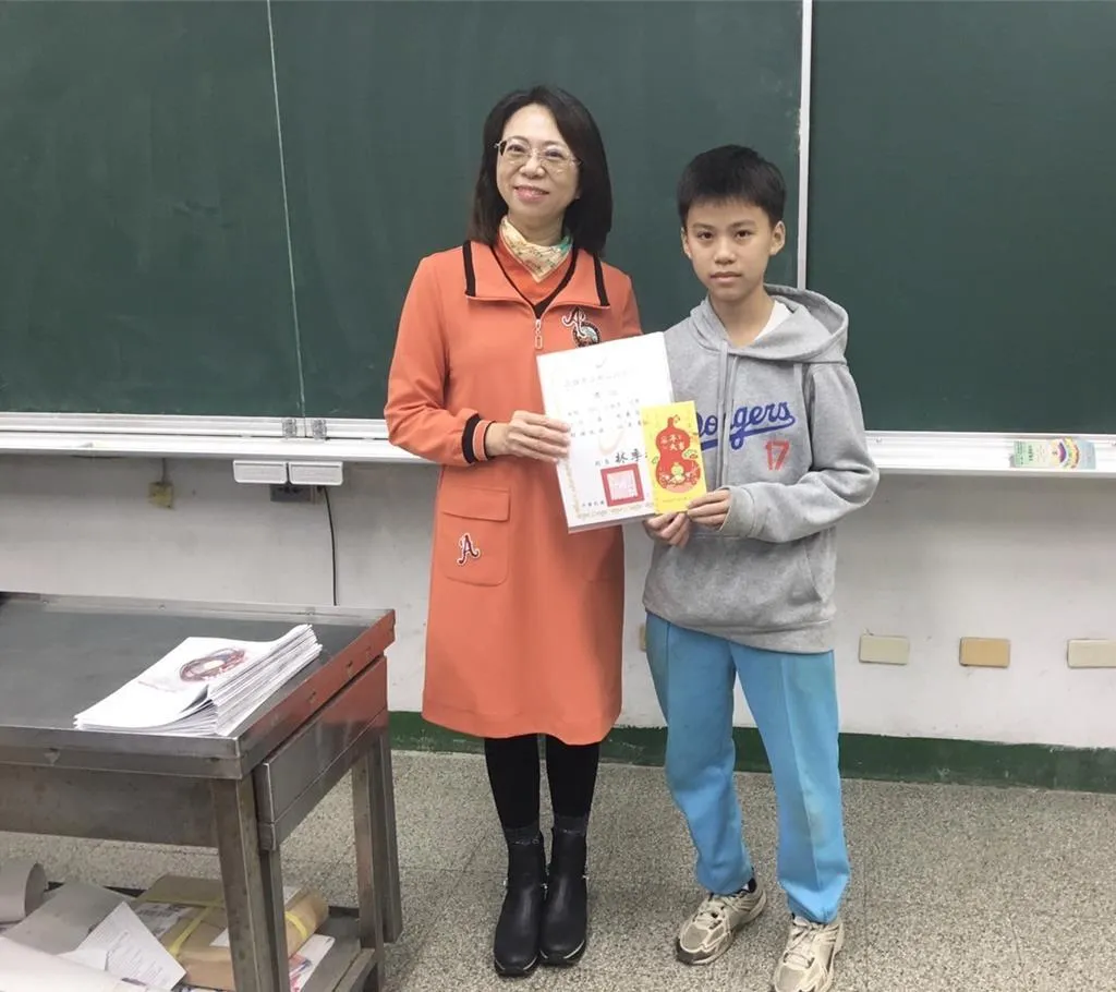 江生（右）牽車護送身障阿伯的暖舉曝光，由校長林季玲在全校集會頒獎狀表揚。（圖／高雄市教育局提供）