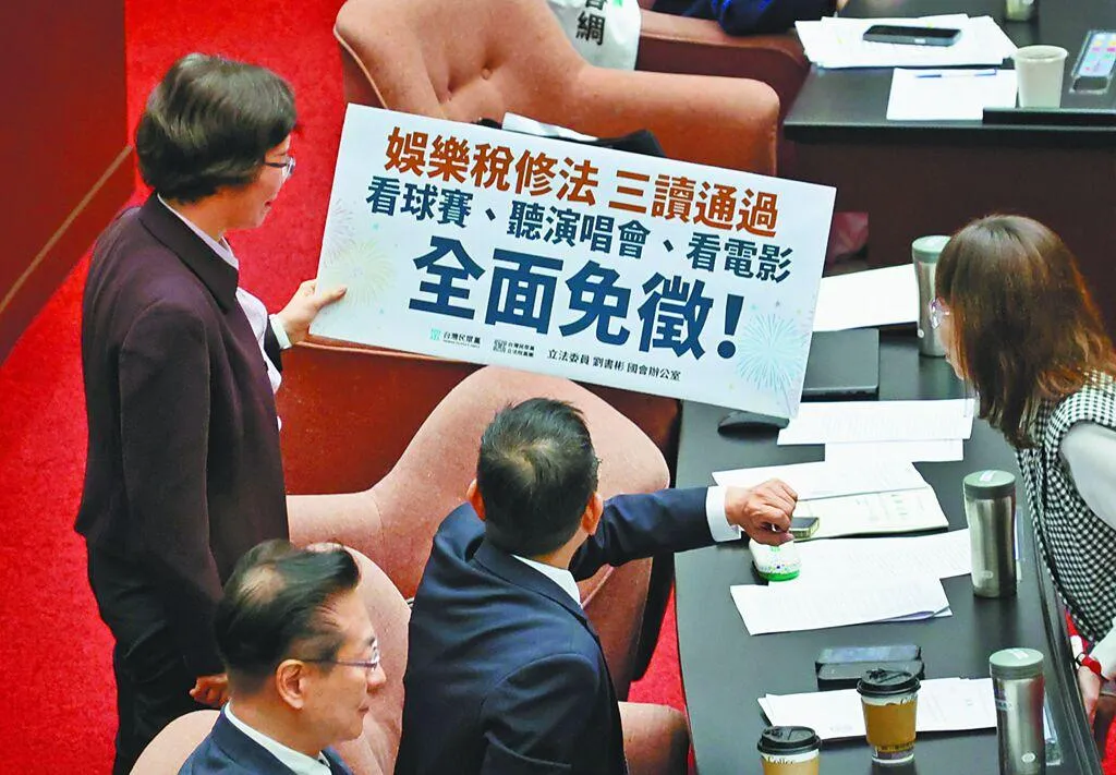 立法院24日院會三讀通過「娛樂稅法部分條文修正草案」，立委劉書彬（左）準備標語上台發言。（圖/中時）