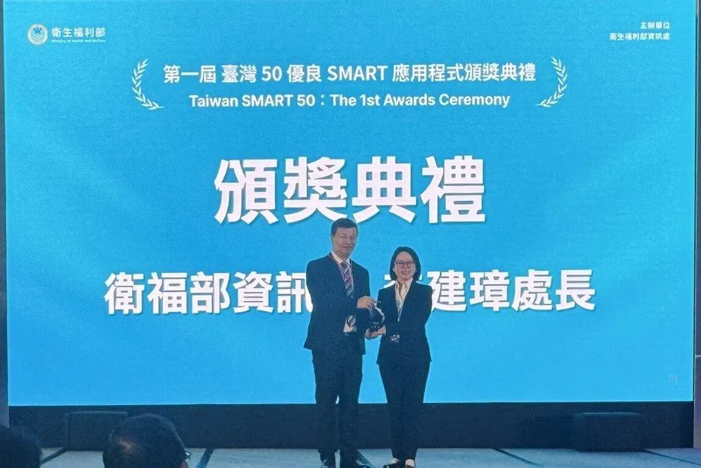 衛生福利部主辦第1屆台灣50優良SMART應用程式競賽，日前舉行頒獎典禮，衛福部資訊處長李建璋（左）親自頒發獎盃，慧德科技總經理李慧鈴（右）受獎。（圖/慧德科技提供）