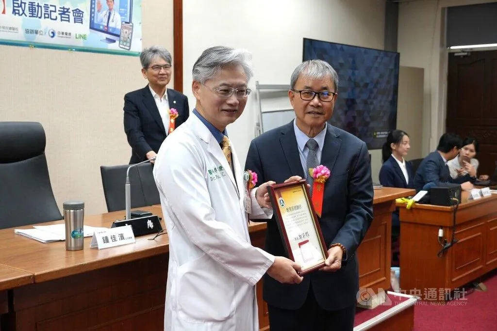 教育部長鄭英耀（前右）頒發感謝狀給遠距醫療平台重要推手、台中榮民總醫院院長傅雲慶（前左）。（圖／中央社）