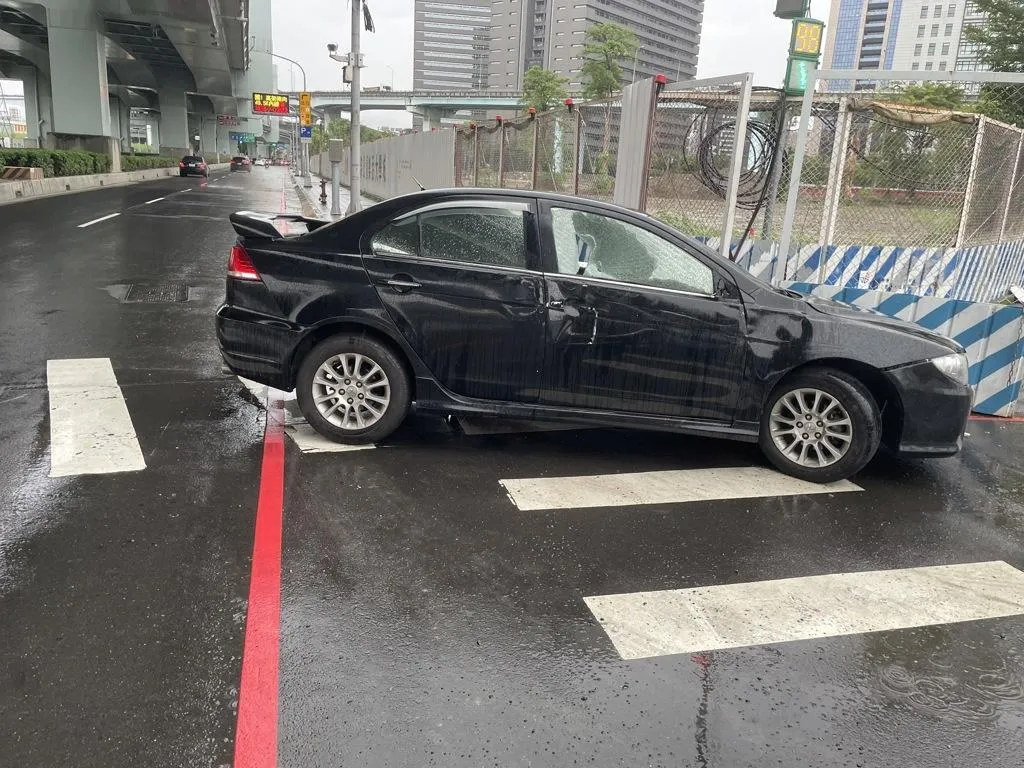 一輛黑色自小客車今（24）日下午行經新莊榮華路二段因拒檢狂飆，逆向衝上泰山捷運站廣場後於新北大道自撞，車上2男棄車逃逸。（圖／警方提供）