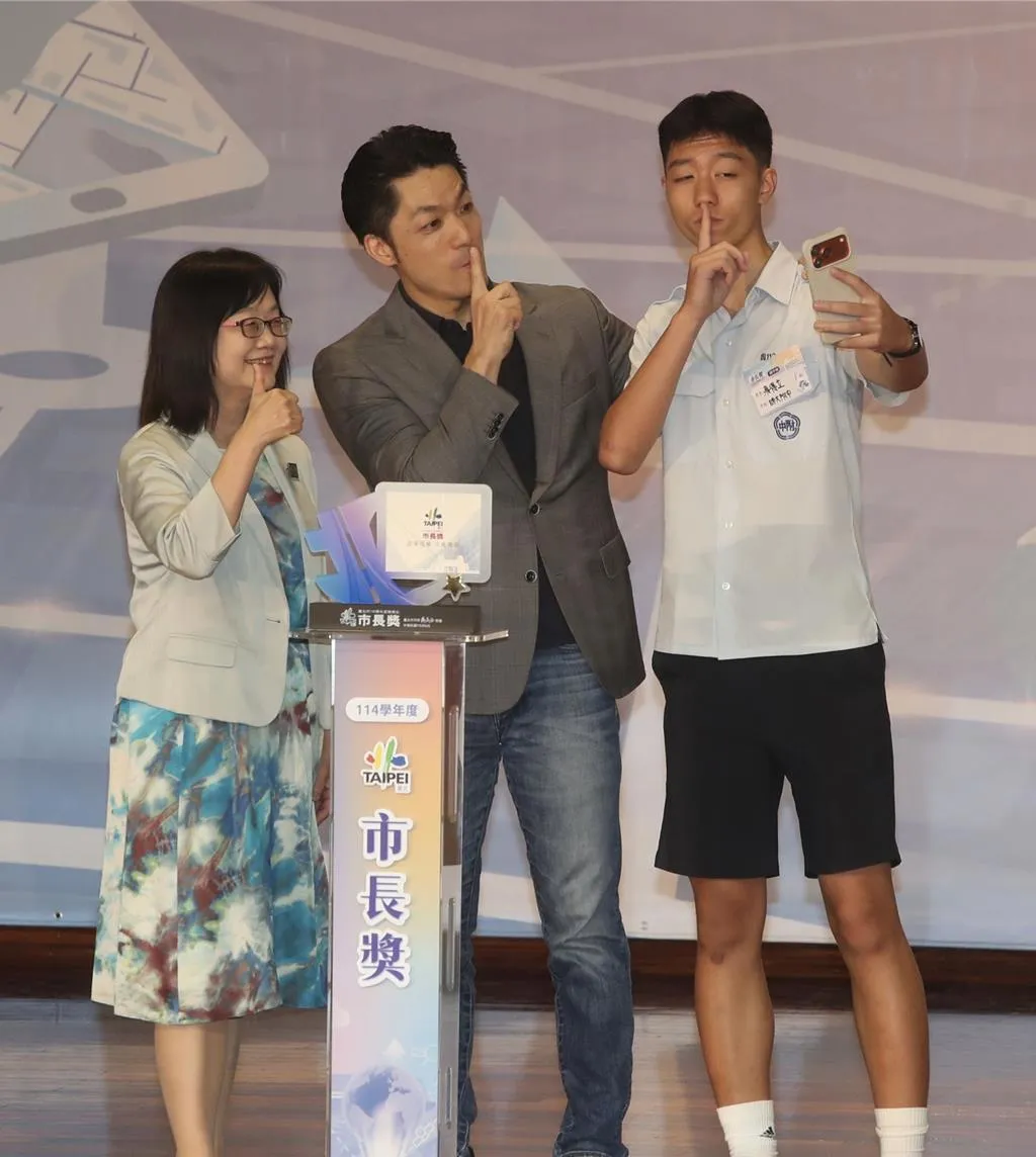 台北市長蔣萬安(中)出席北市公私立國中114學年度畢業生市長獎頒獎典禮,還親自頒獎給兒子「大寶」蔣得立(右),還與大寶擺出南韓知名電競選手Faker招牌姿勢,相當有趣。(資料照/中時陳君瑋攝)
