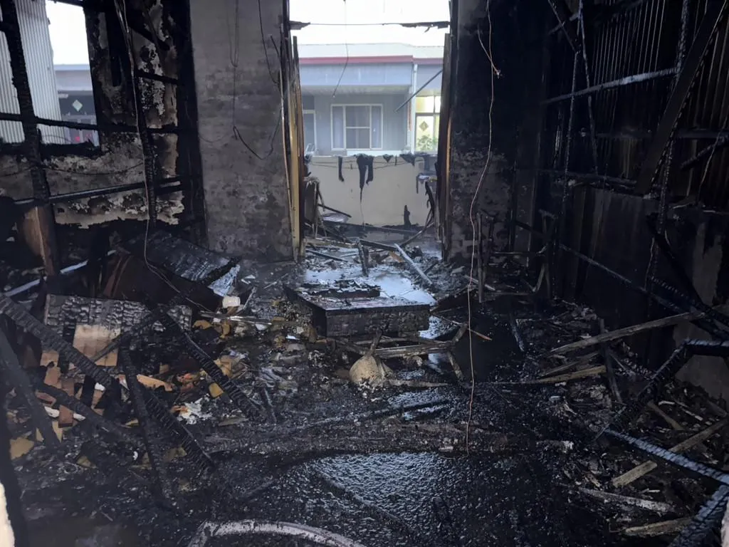 現場一片狼藉，3樓鐵皮屋頂燒毀嚴重，部分住戶的家具與家電遭大火波及。（圖／翻攝畫面）