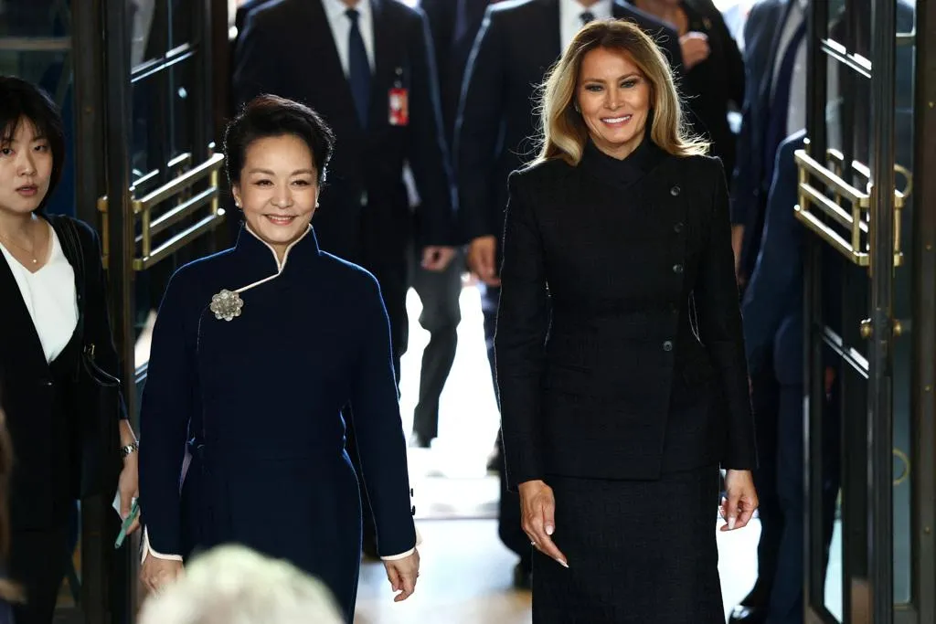習近平的夫人彭麗媛，美東時間24日由美國總統川普的夫人梅蘭妮亞陪同參訪位於華府的史密森尼博物館。兩人步入大門時露出燦爛笑容。（圖/路透）
