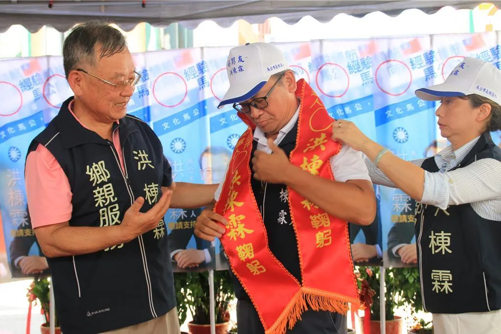 前澎湖縣長賴峰偉(左)幫洪棟霖(中)披上競選彩帶。(中時許逸民攝)