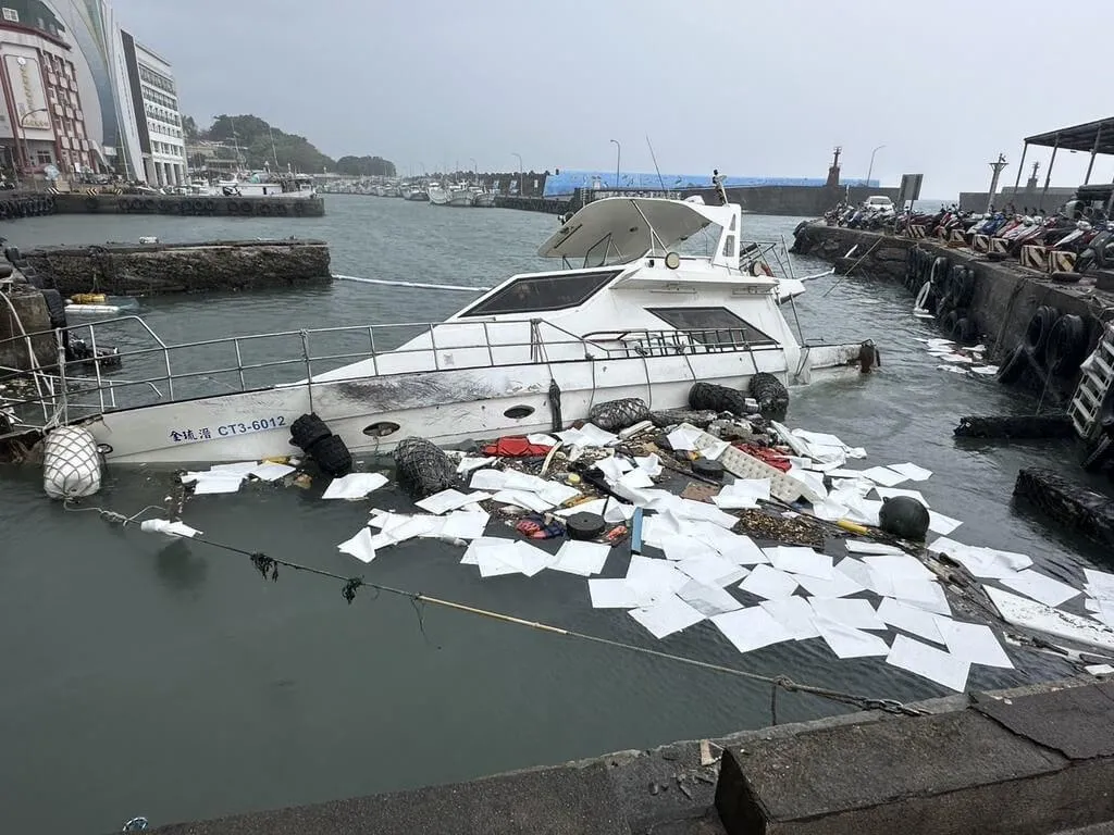 一艘停泊於小琉球白沙漁港的枋寮籍漁船,因23日晚間受強浪衝擊斷纜漂流,致船身破損,隔日凌晨進水下沉。海巡人員設攔油防線防止油污擴散。(圖/海巡署南部分署第五岸巡隊提供)