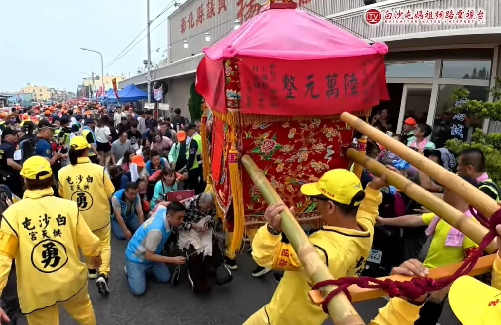 轎班人員高抬鑾轎讓老翁能夠順利從神轎下方穿過。（圖／翻攝自白沙屯媽祖網路電視台）