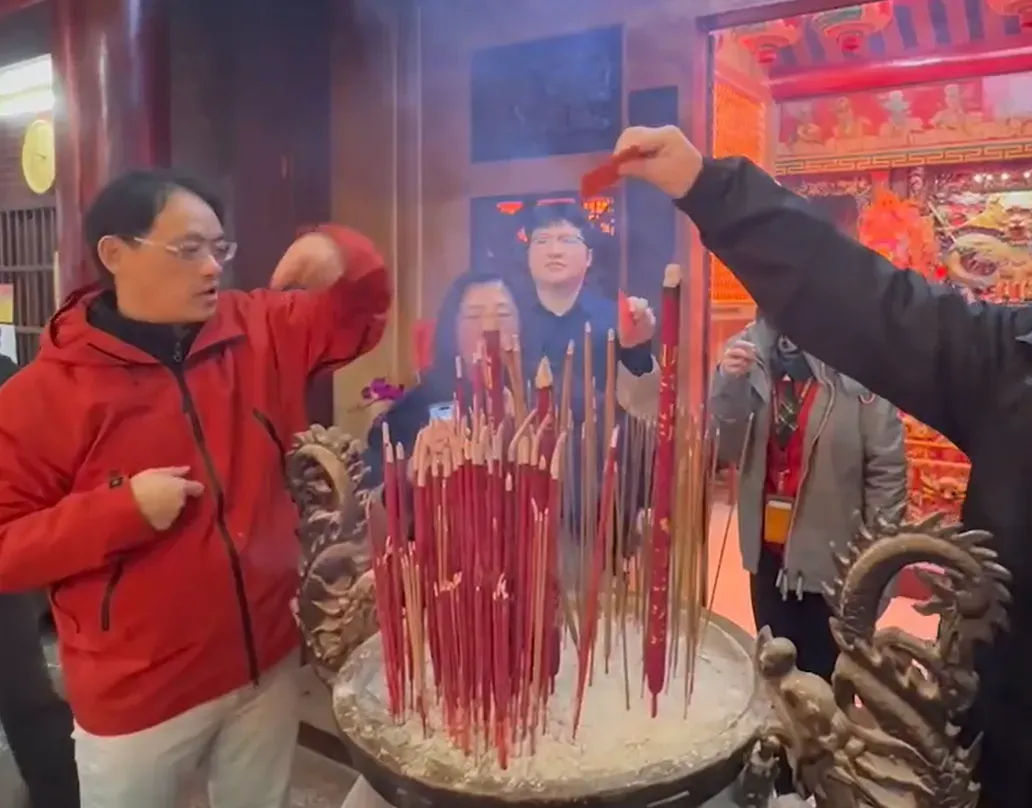 民眾拿著紅包過香爐，祈禱今年財運滾滾、平平安安。（圖／翻攝畫面）