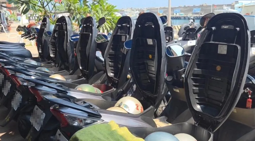 由於小琉球夏季炎熱，機車座墊在烈日照射下溫度急速升溫，騎士們因此在停車時將座墊打開，藉此散熱防止座墊過燙。（圖／翻攝畫面）