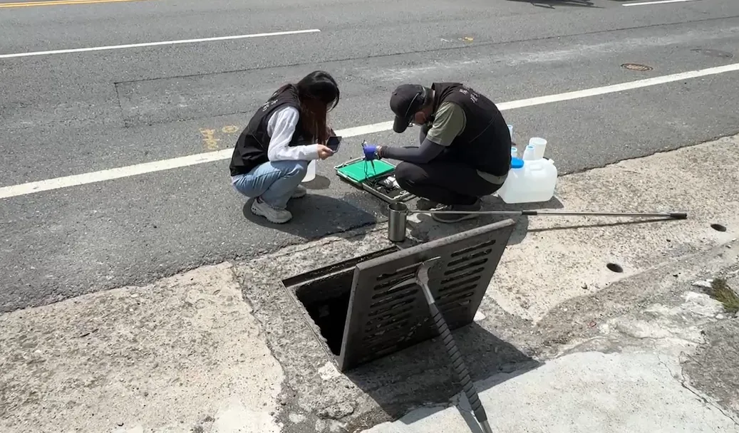 環保局到場檢驗路旁排水溝的水。（圖／中天新聞）