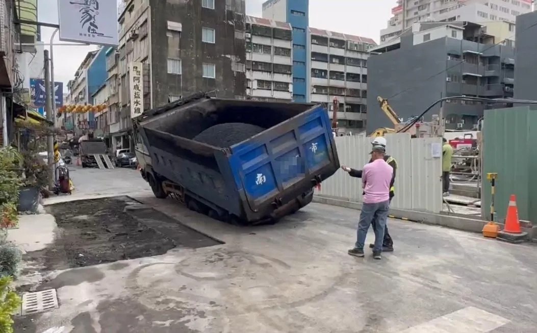 一輛貨車今（21）日上午行經台南市五妃街時，後輪突然被路面塌陷的破洞吞噬。（圖／中天新聞）