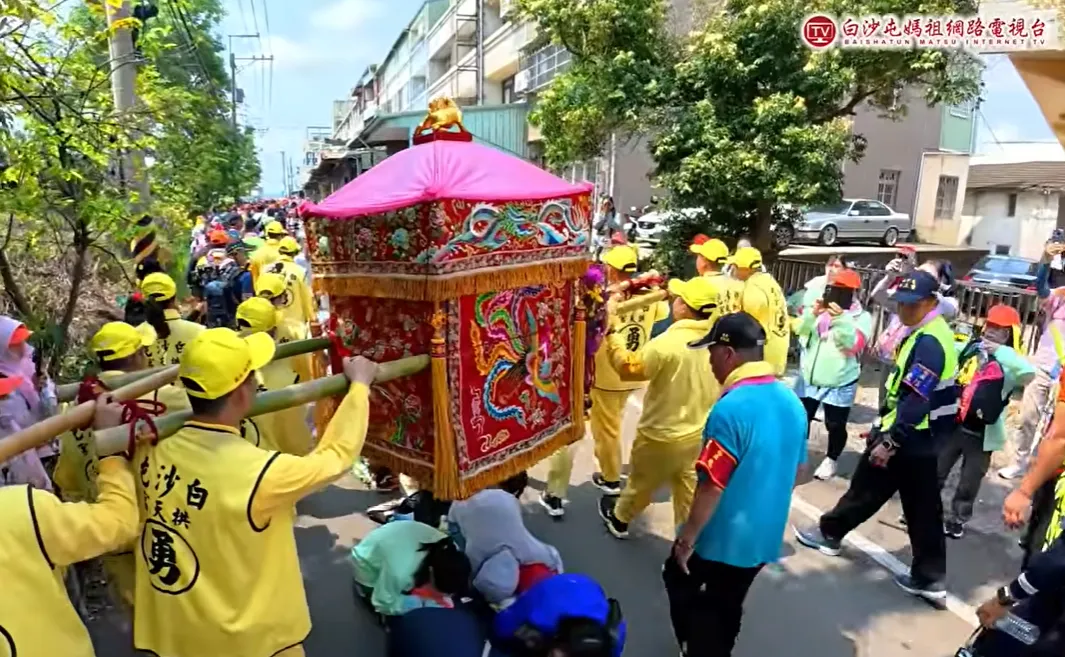 白沙屯媽祖鑾轎旁，總是跟著一名穿藍衣、戴紅臂章的男子。（圖／翻攝自白沙屯媽祖網路電視台YT）