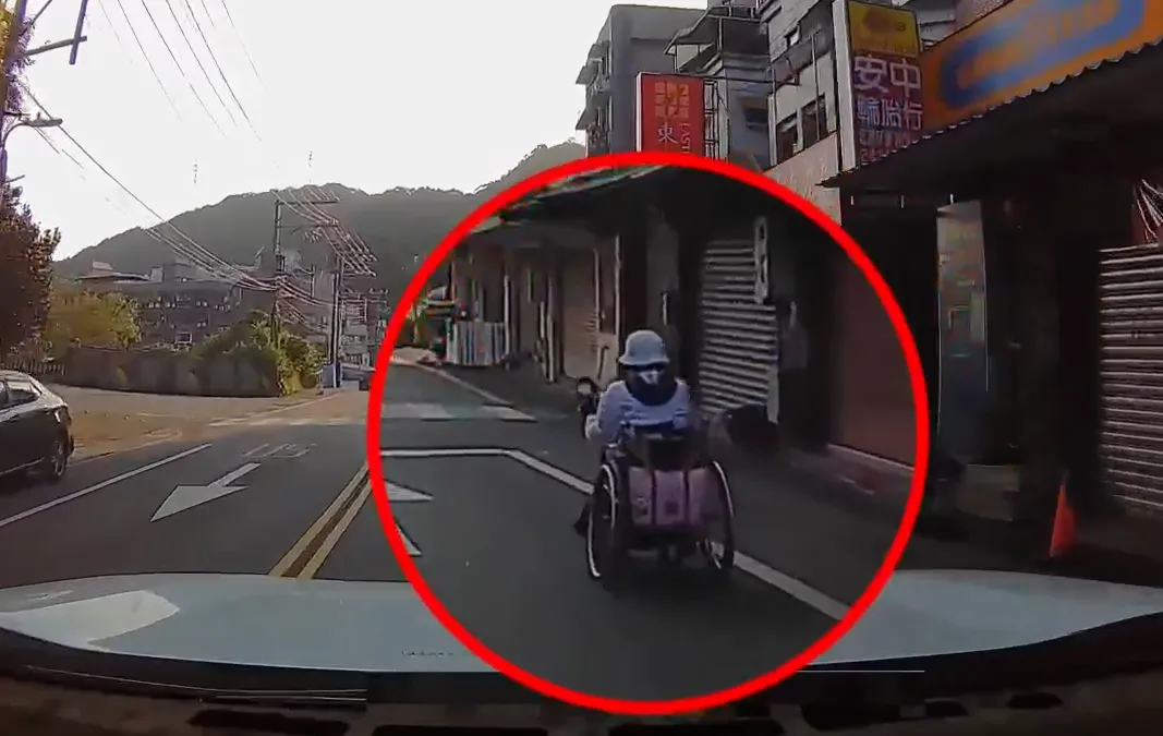 一名老婦人獨自乘坐電動輪椅，直接行駛在汽機車穿梭的大馬路上。（圖／民眾提供）