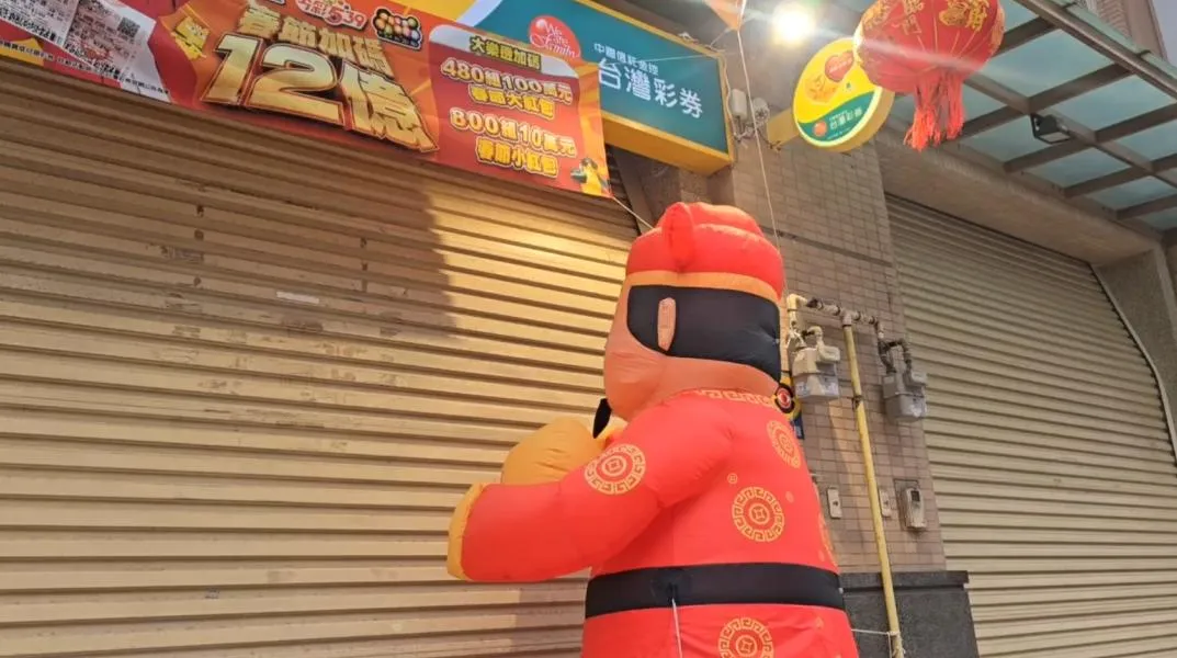 農曆新年將至，一支在新竹市彩券行外瘋狂「敲門」的財神爺氣球，意外成為網路熱議話題。（圖／翻攝畫面）