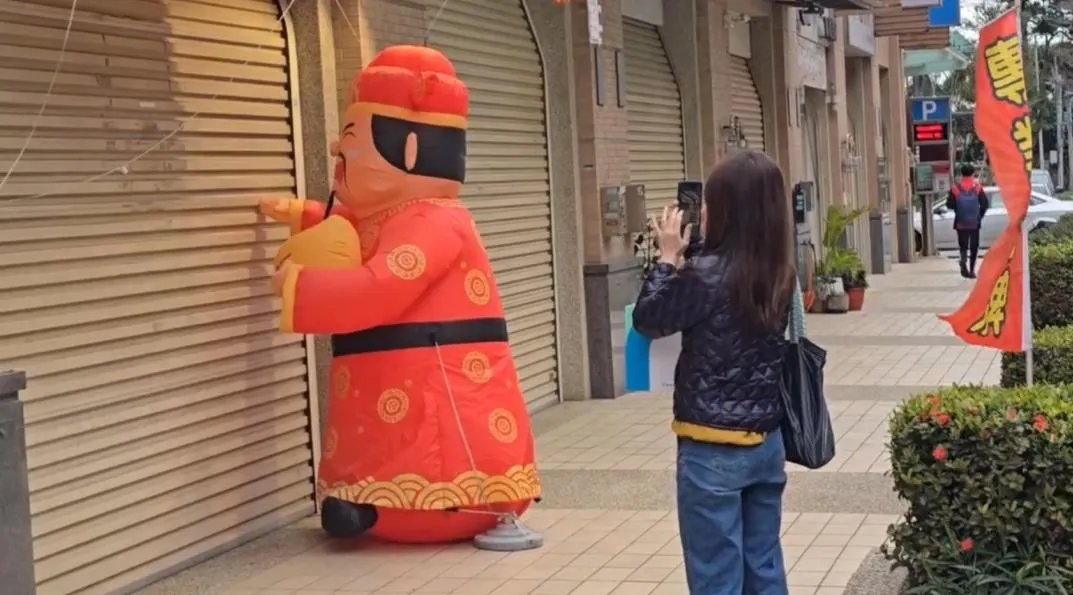 農曆新年將至，一支在新竹市彩券行外瘋狂「敲門」的財神爺氣球，意外成為網路熱議話題。（圖／翻攝畫面）