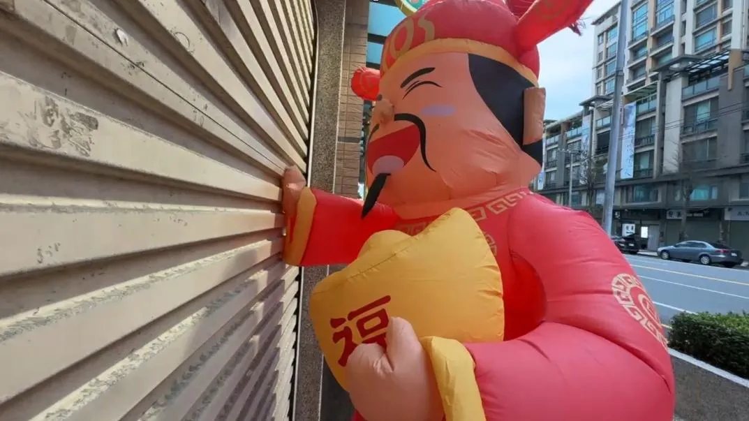 農曆新年將至，一支在新竹市彩券行外瘋狂「敲門」的財神爺氣球，意外成為網路熱議話題。（圖／翻攝畫面）
