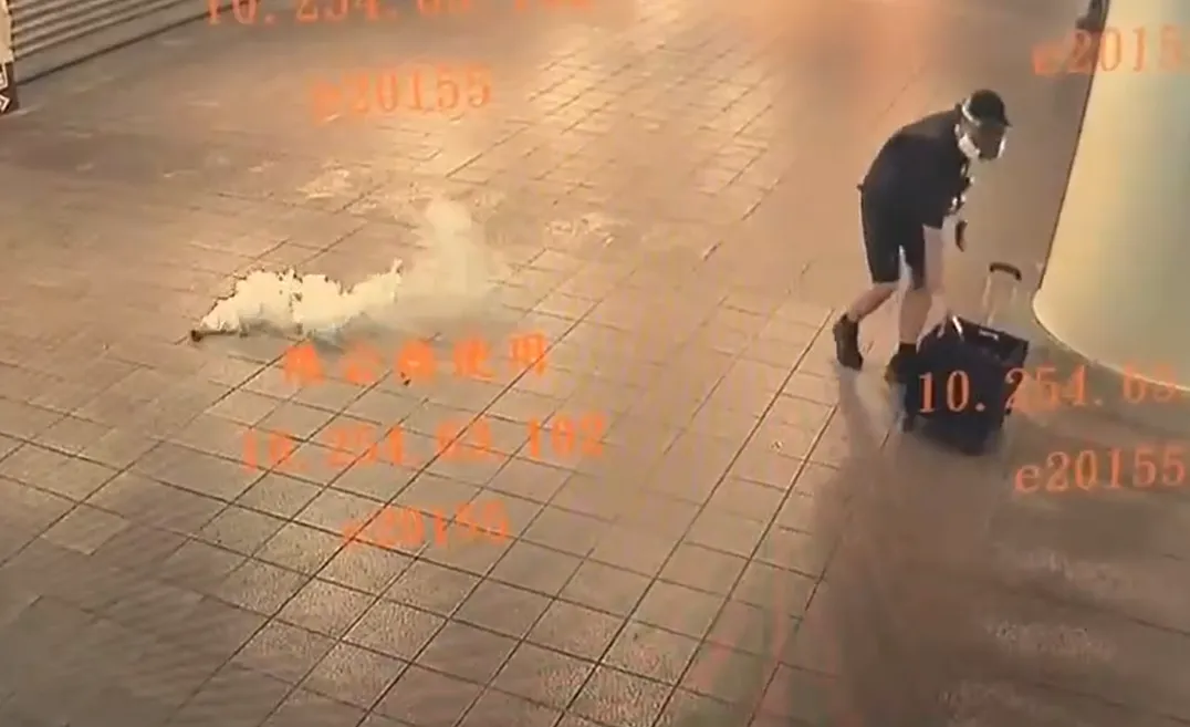 作案瞬間曝光,一名嫌犯頭戴防毒面罩,在北捷出口處連續丟擲多顆煙霧彈,現場瞬間濃煙四起,刺鼻氣味瀰漫。(圖/警方提供)