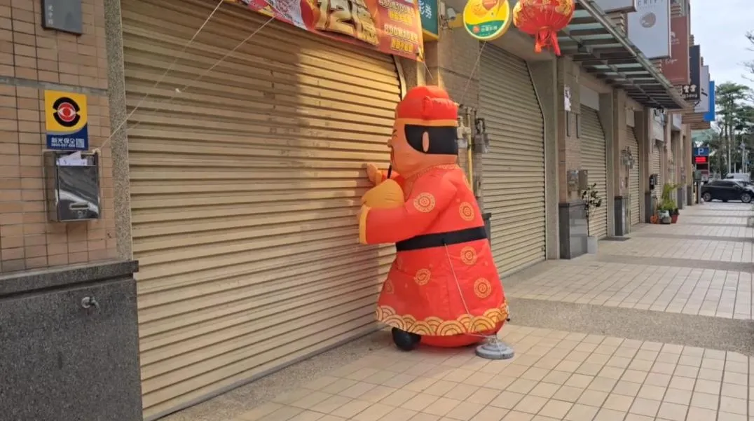 農曆新年將至，一支在新竹市彩券行外瘋狂「敲門」的財神爺氣球，意外成為網路熱議話題。（圖／翻攝畫面）
