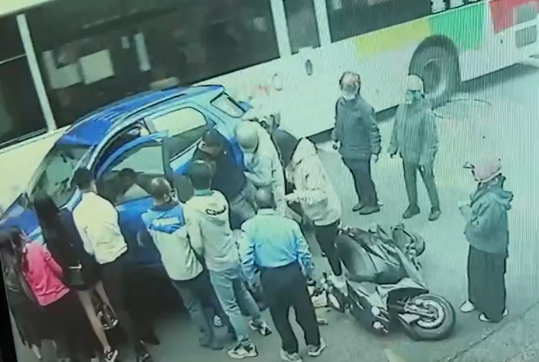 附近民眾發現小客車駕駛的動作，紛紛上前協助抬車並順利救出底下的賴姓騎士。（圖／翻攝畫面）